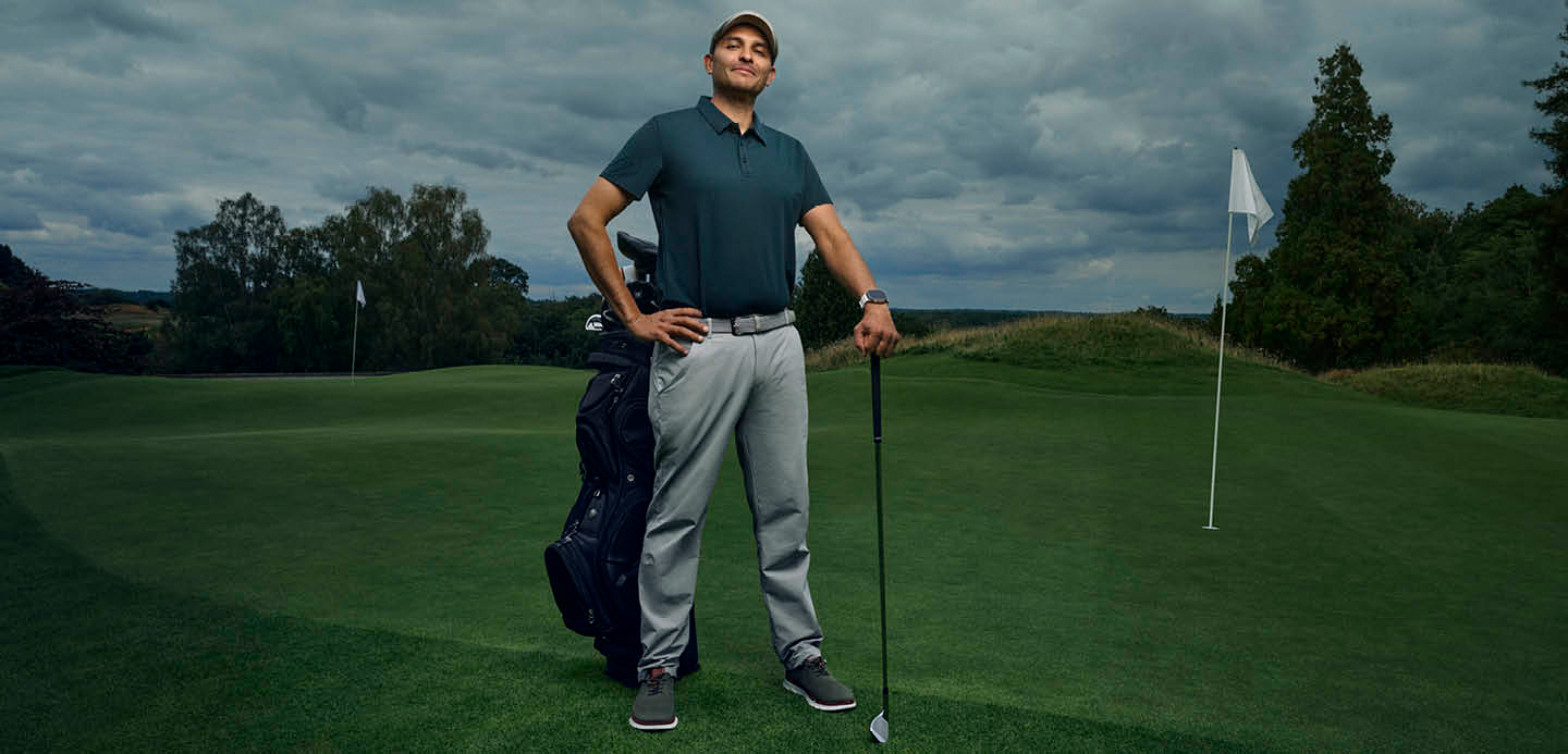 Nikhil stood leaning his left hand on a golf club in the middle of a golf course. Nikhil stood leaning his left hand on a golf club in the middle of a golf course.
