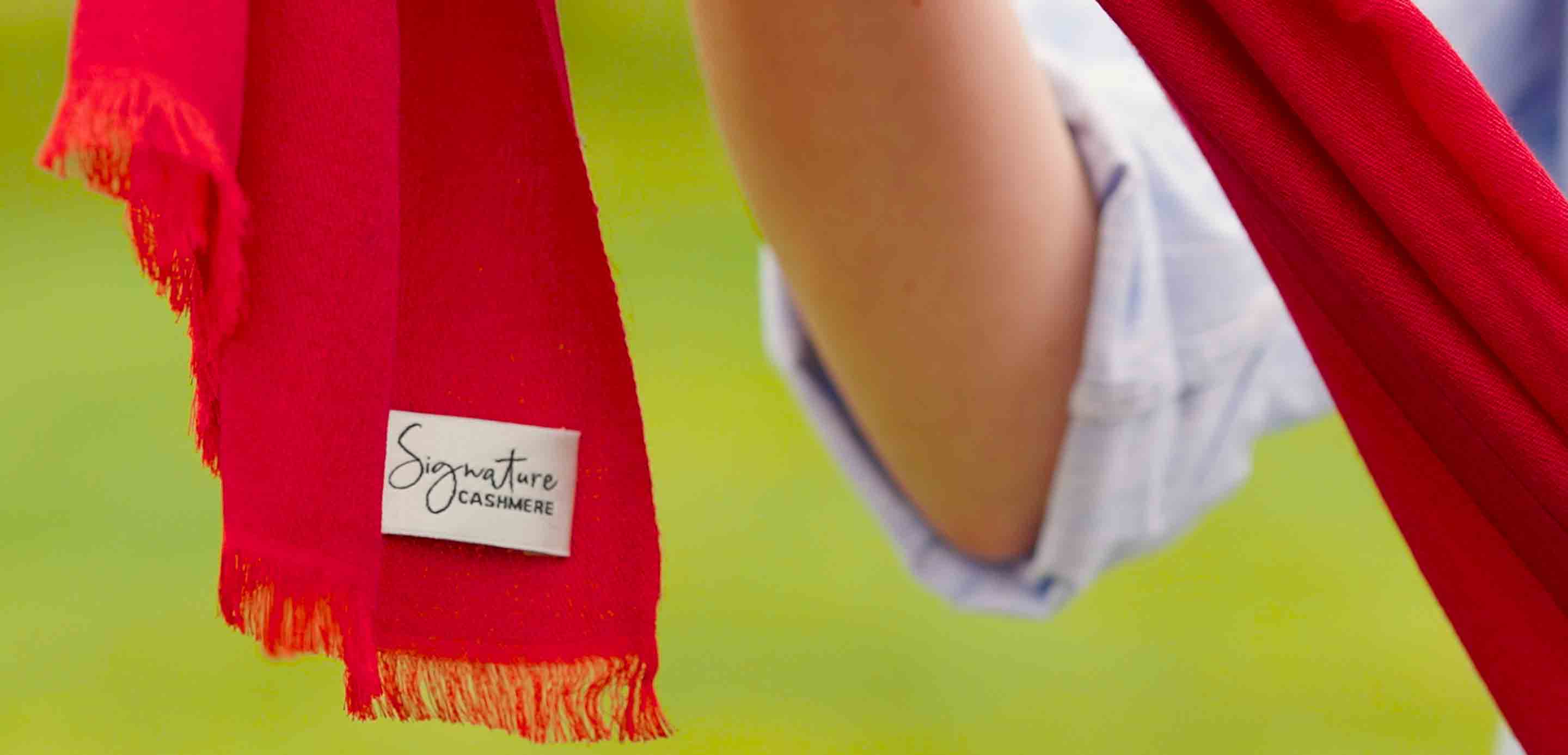Close up of a person holding a red Signature Cashmere scarf