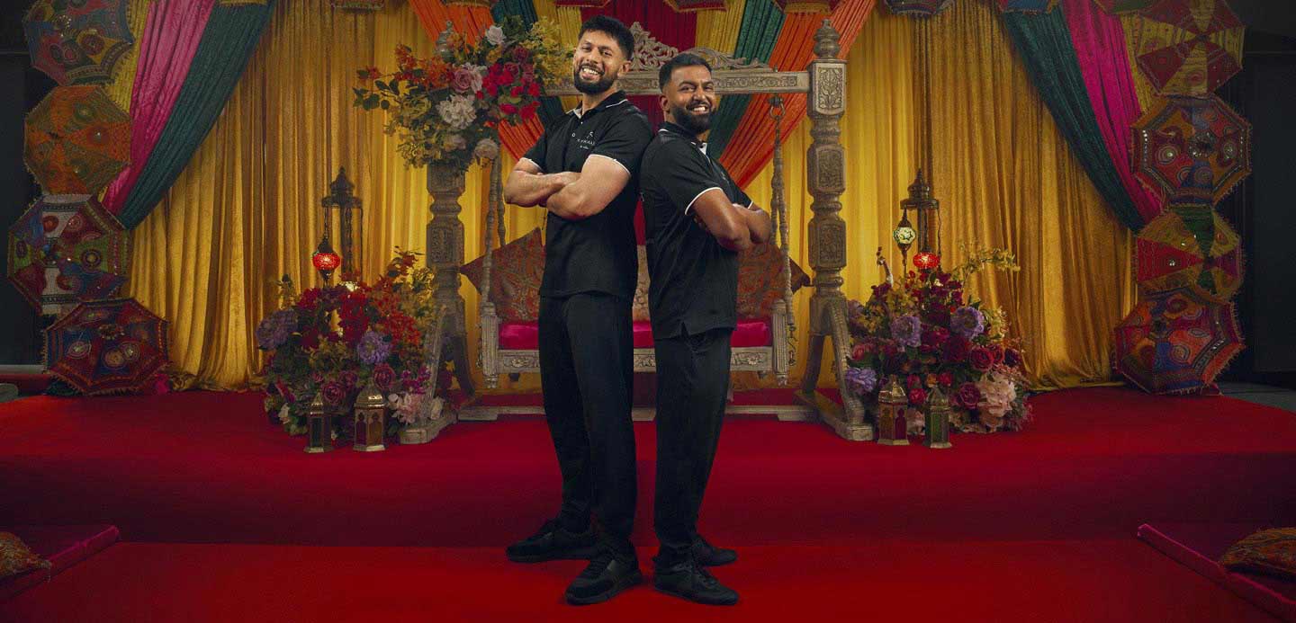 Faraz and Ayan back-to-back with their arms crossed stood in front of their event decor. Faraz and Ayan back-to-back with their arms crossed stood in front of their event decor.