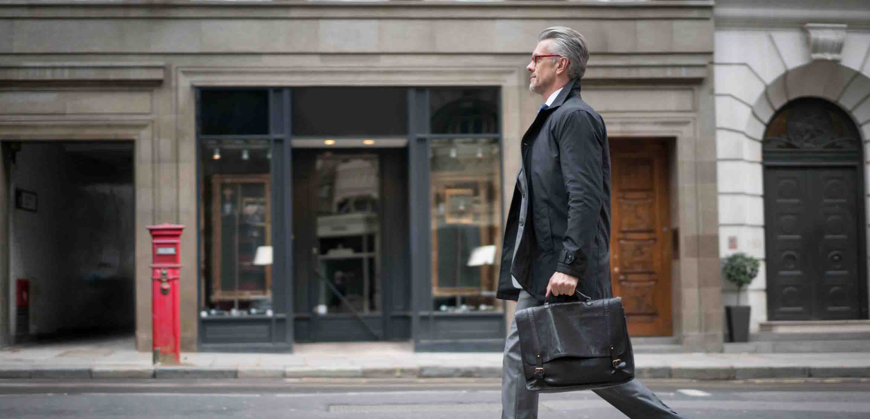 Businessman walking down a street with a briefcase Businessman walking down a street with a briefcase