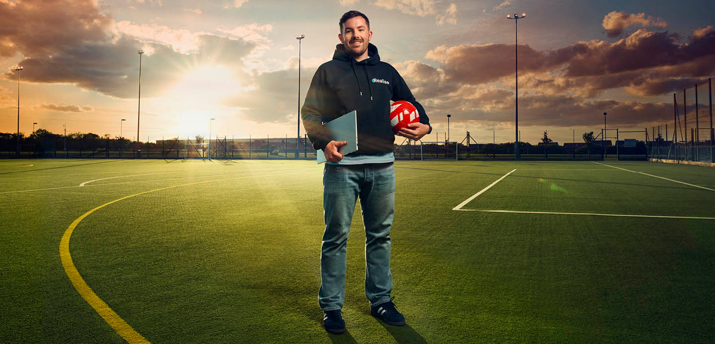 Will standing in the middle of a football pitch holding a football and notebook. Will standing in the middle of a football pitch holding a football and notebook.