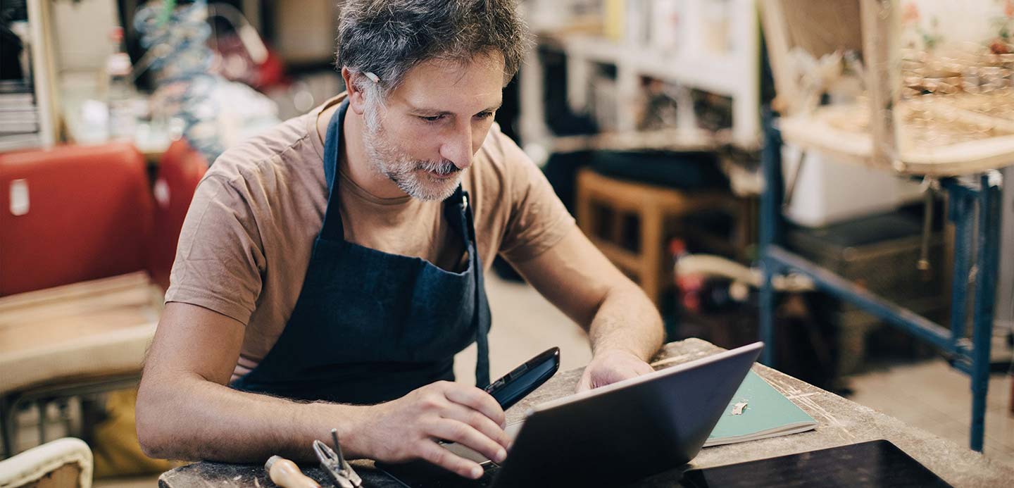 Man in workshop working on laptop Man in workshop working on laptop