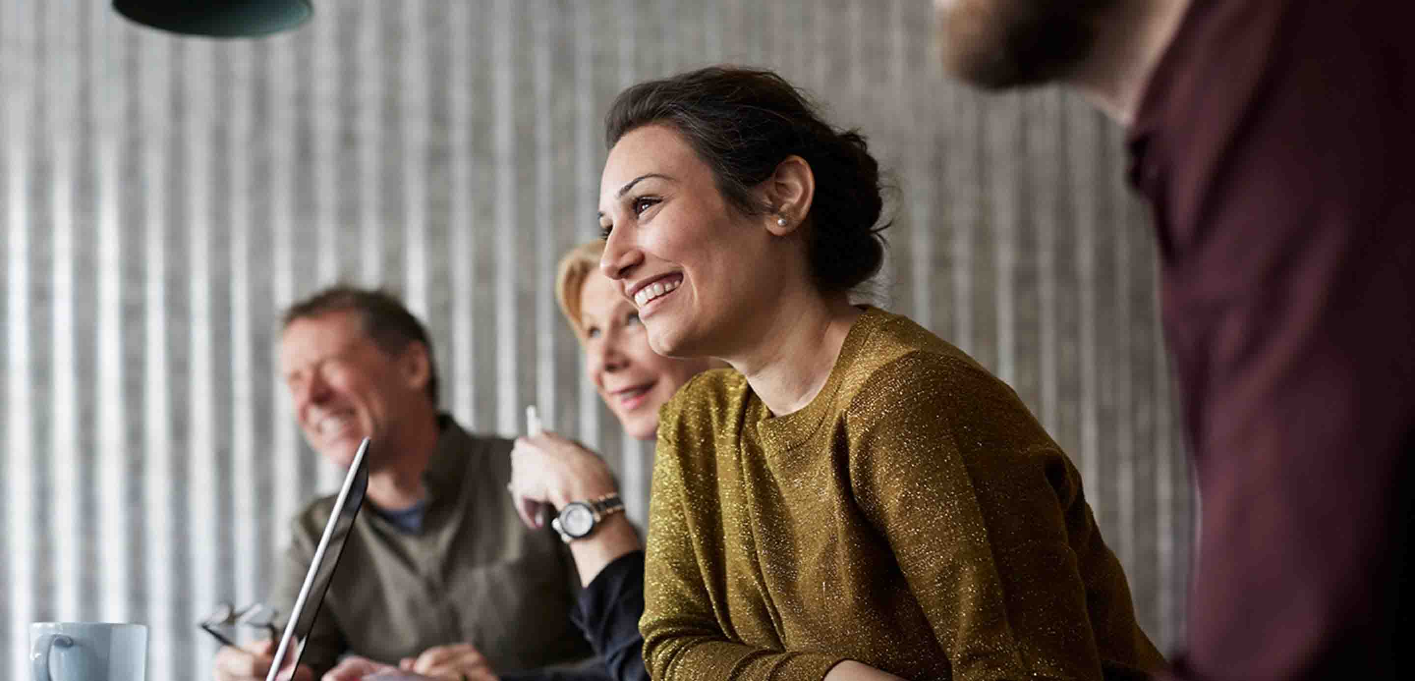 People smiling and laughing at a table in an office