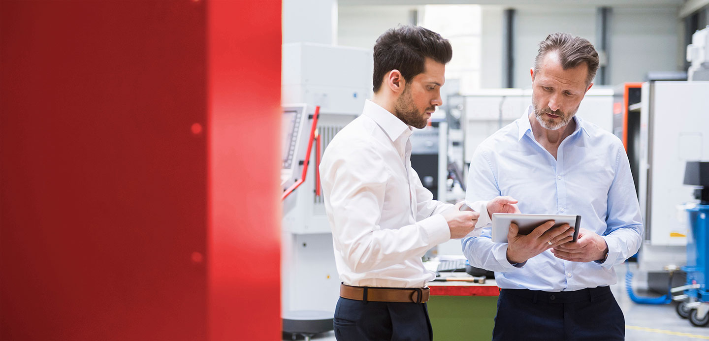 Two gentlemen looking at a report on a tablet