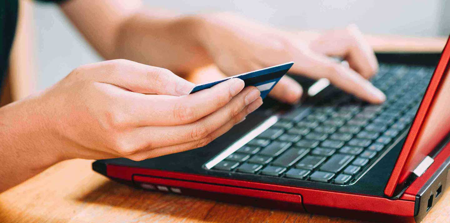 Woman entering credit card details onto a laptop